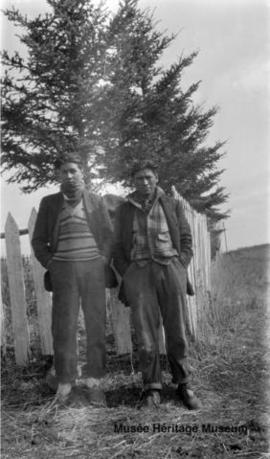 Two men standing at the old mission at Onion Lake, Saskatchewan