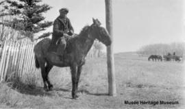 Eli Singer or Antoine Littlewolfe on a horse near the old mission at Onion Lake, Saskatchewan.